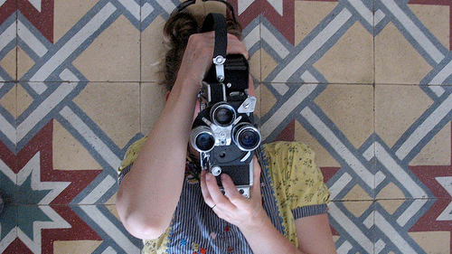 A portrait of Kathryn Ramey holding a Bolex Camera